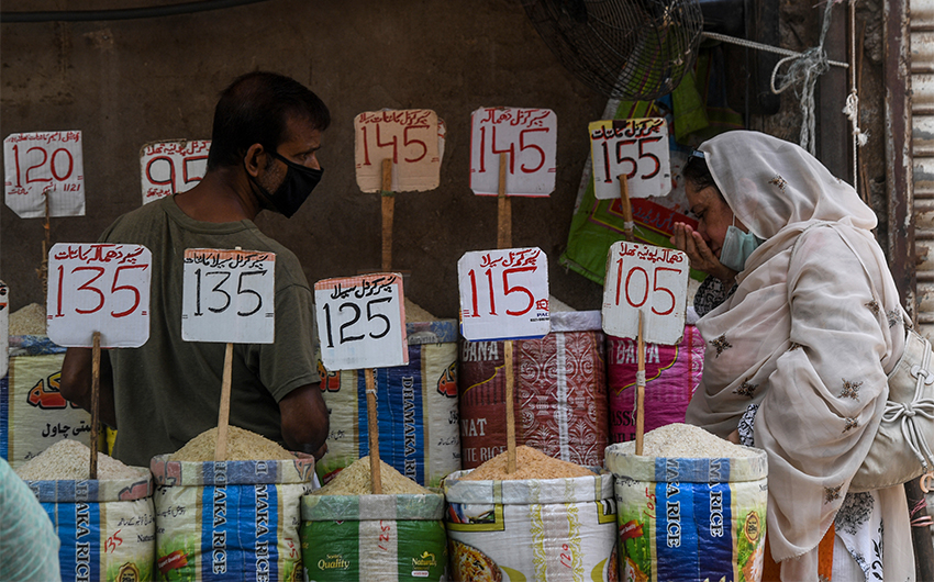 A woman checks the smell of rice at a market in Karachi on June 10, 2020. (AFP/File)
