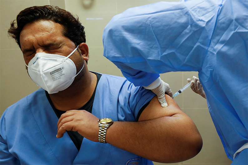 A health worker reacts while receiving a dose of the Sinopharm coronavirus disease (COVID-19) vaccine, donated by China, at a vaccination centre in Karachi, Pakistan February 3, 2021. (REUTERS)