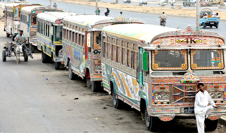 A Pakistani man rides his donkey-cart as he passes by parked buses along with road side in Karachi on July 22, 2008. (AFP)