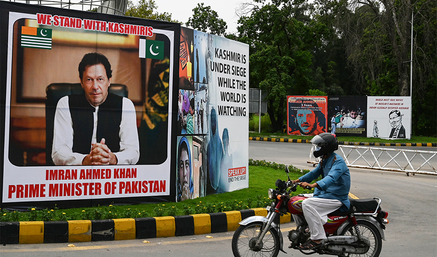 A motorcyclist rides past a billboard displaying a picture of Pakistan's Prime Minister Imran Khan along a street in Islamabad on August 4, 2020. (AFP/File)