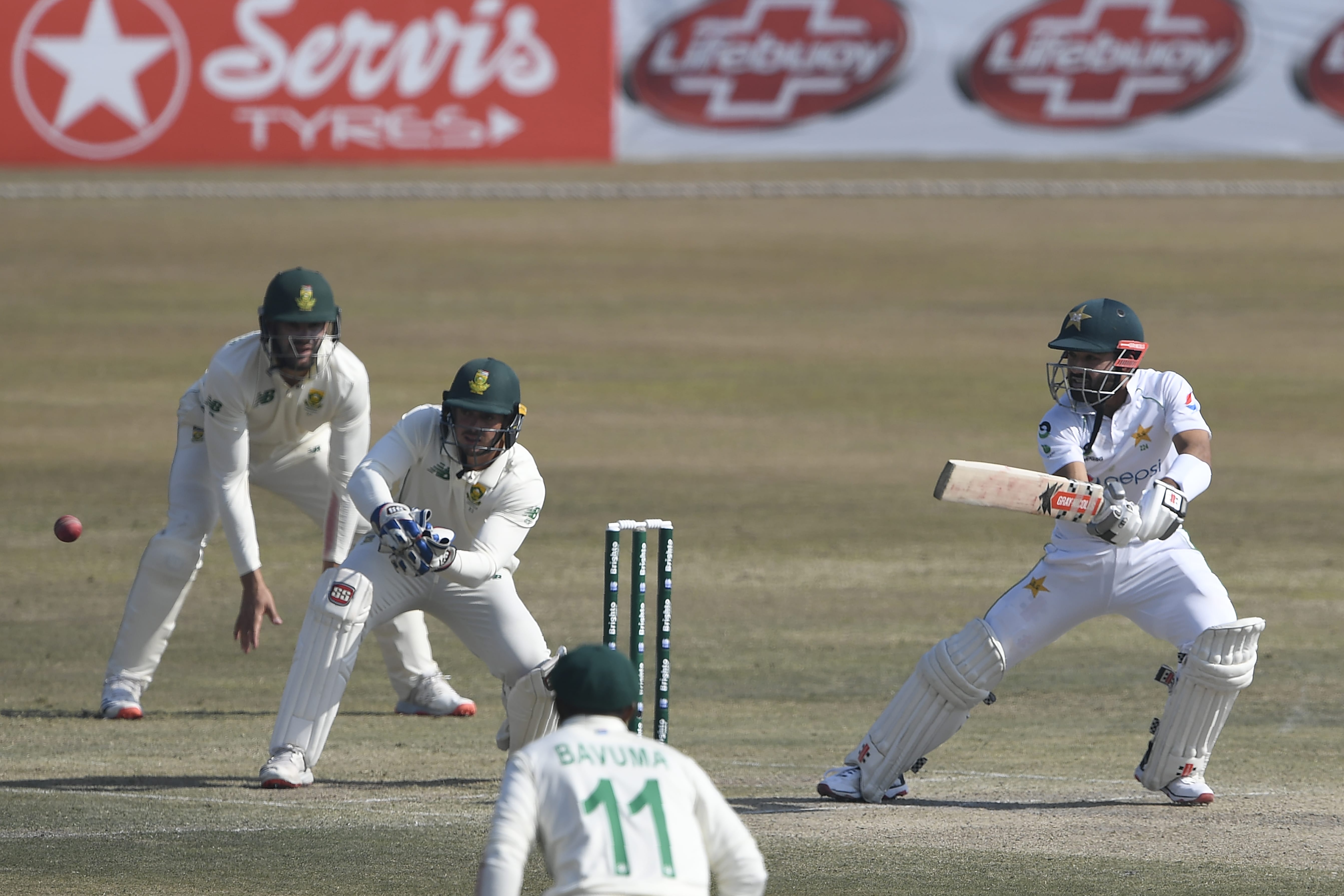 Pakistan's Mohammad Rizwan (R) plays a shot as South Africa's wicketkeeper captain Quinton de Kock (2L) watches during the fourth day of the second Test cricket match between Pakistan and South Africa at the Rawalpindi Cricket Stadium in Rawalpindi on February 7, 2021. (AFP)