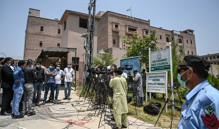 Media personnel report outside a court after a verdict of a high profile murder case of an influential Pakistani politician Imran Farooq, in Islamabad on June 18, 2020. (AFP)