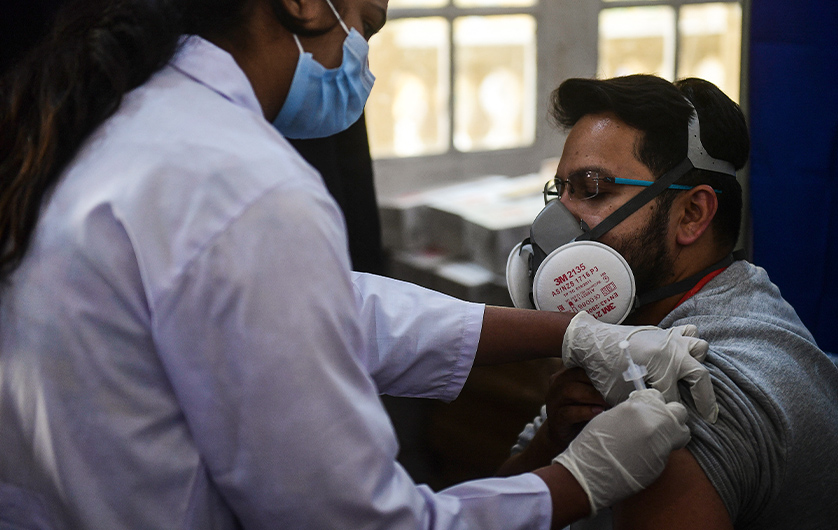 A health worker (R) receives a dose of the Chinese-made Sinopharm Covid-19 vaccine, at a vaccination centre in Karachi on February 3, 2021. (AFP)