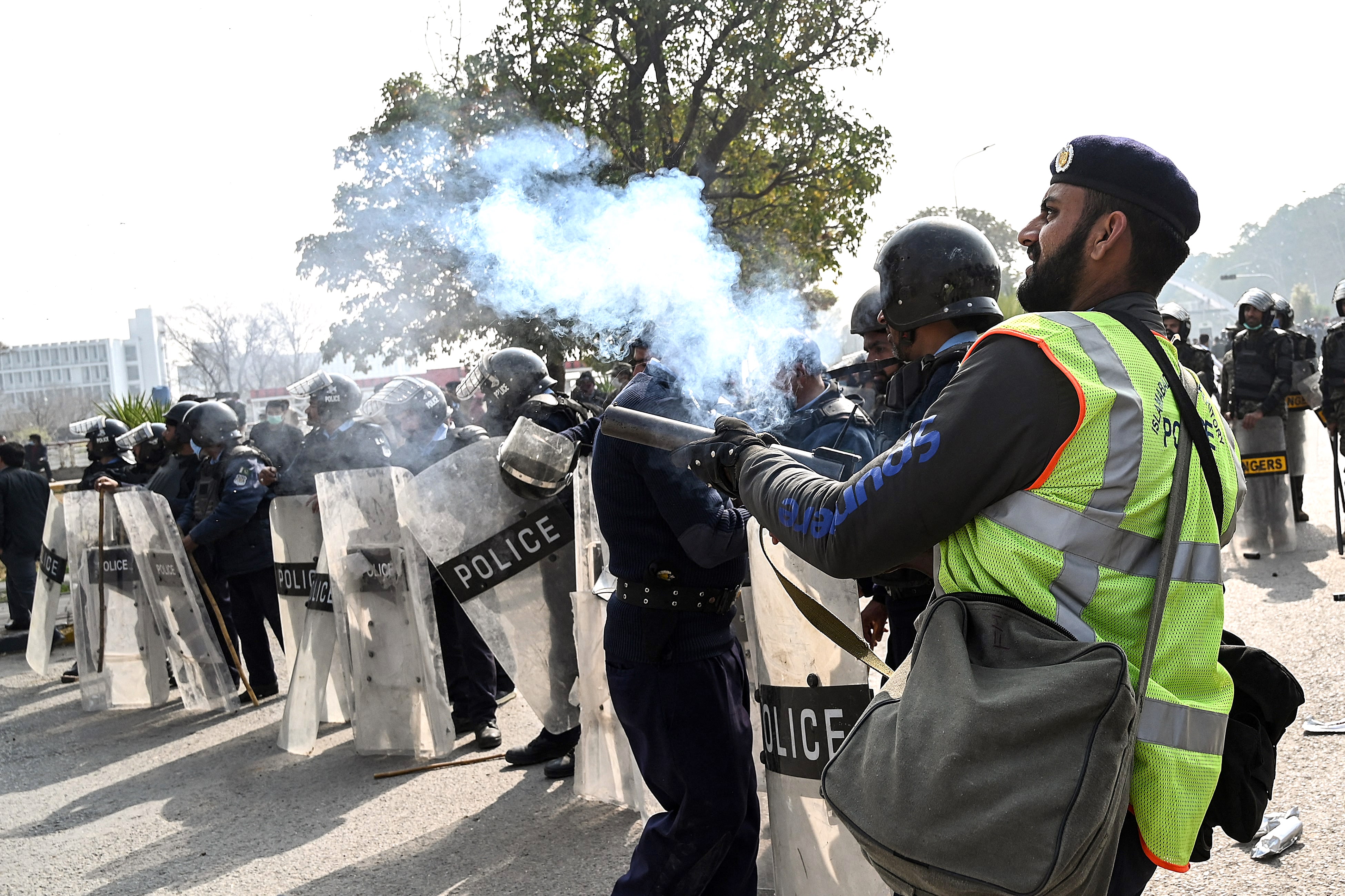 Policemen fire teargas shells toward federal government employees to disperse them as they march toward the Parliament House during a protest to demand higher wages, in Islamabad on February 10, 2021. (AFP)