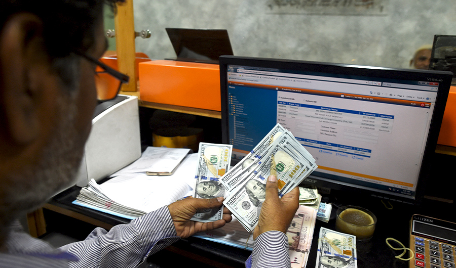 A Pakistani dealer counts US dollars at a currency exchange shop in Karachi on November 30, 2018. (AFP)