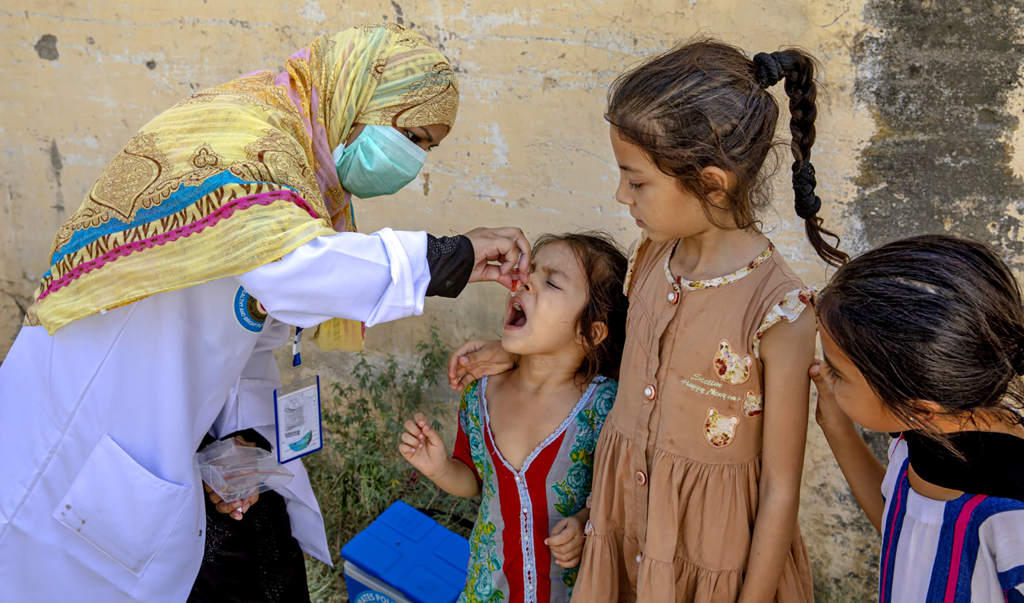 This undated photo shared by Emirates News Agency (WAM) on February 20, 2021, shows a health worker vaccinating Pakistani children against polio under UAE-Pakistan Assistance Program. (WAM)