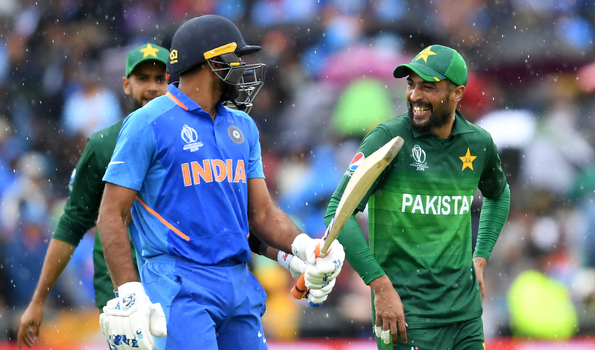 Pakistan's Mohammad Amir, right, speaks with India's Vijay Shankar as they walk back to the pavilion as rain stops play during the 2019 Cricket World Cup group stage match at Old Trafford in Manchester, northwest England, on June 16, 2019. (AFP/File)