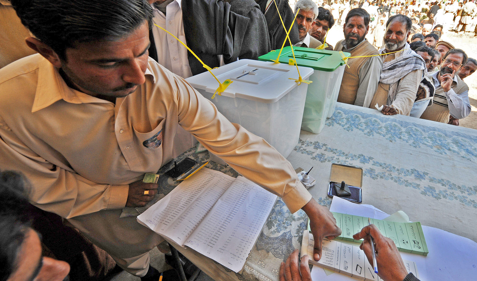 Pakistanis wait to cast their votes at a polling station in Sialkot, Pakistan, on February 18, 2008. (AFP/File)