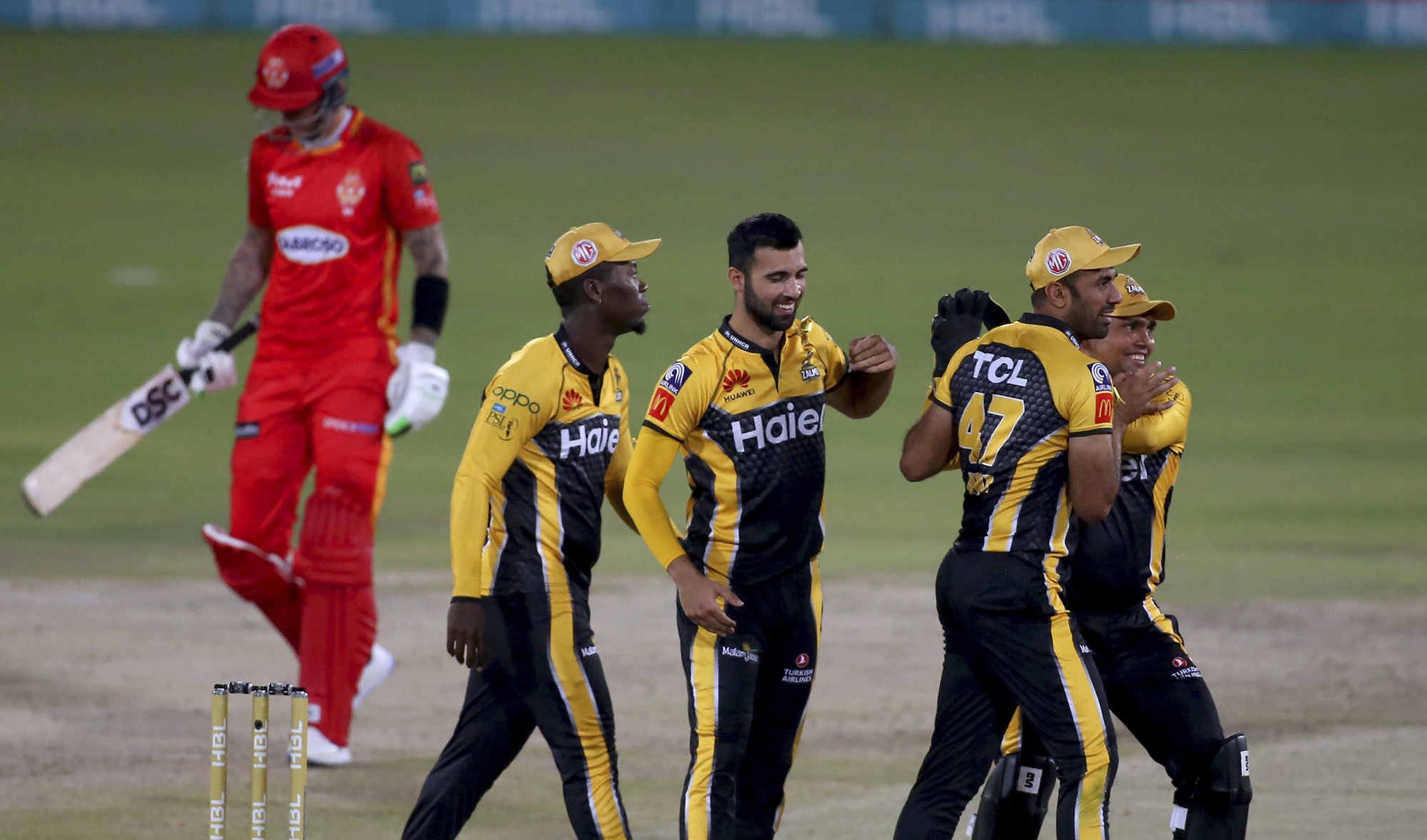Peshawar Zalmi' Saqib Mahmood, center, celebrates with teammates after taking the wicket of Islamabad United' Alex Hales, left, during Pakistan Super League match at the National Stadium Karachi, Pakistan, on February 27, 2021. (AP)