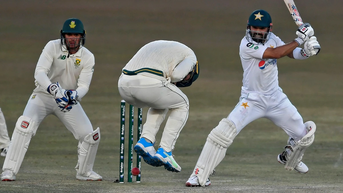 Pakistan's Mohammad Rizwan (R) plays a shot as South Africa's wicketkeeper captain Quinton de Kock (L) watches during the third day of the second Test cricket match between Pakistan and South Africa at the Rawalpindi Cricket Stadium in Rawalpindi on Feb. 6, 2021. (AFP)