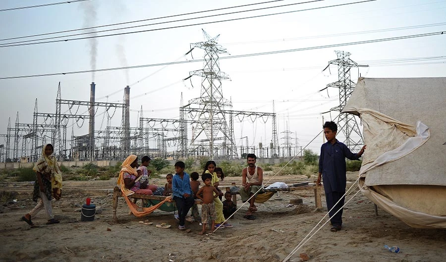 A family sits by its tent in front of DPS thermal power station in Muzaffargah, Punjab Province Pakistan, on September 5, 2010. (AFP)