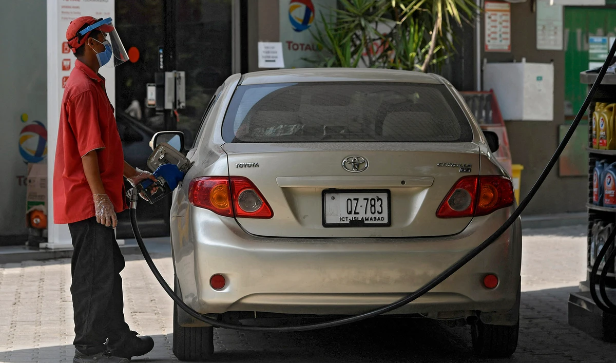 An employee wearing a face shield and mask as a precautionary measure against the spreading COVID-19 coronavirus fills the tank of a car at a petrol station in Islamabad, Pakistan on July 9, 2020. (AFP/File)