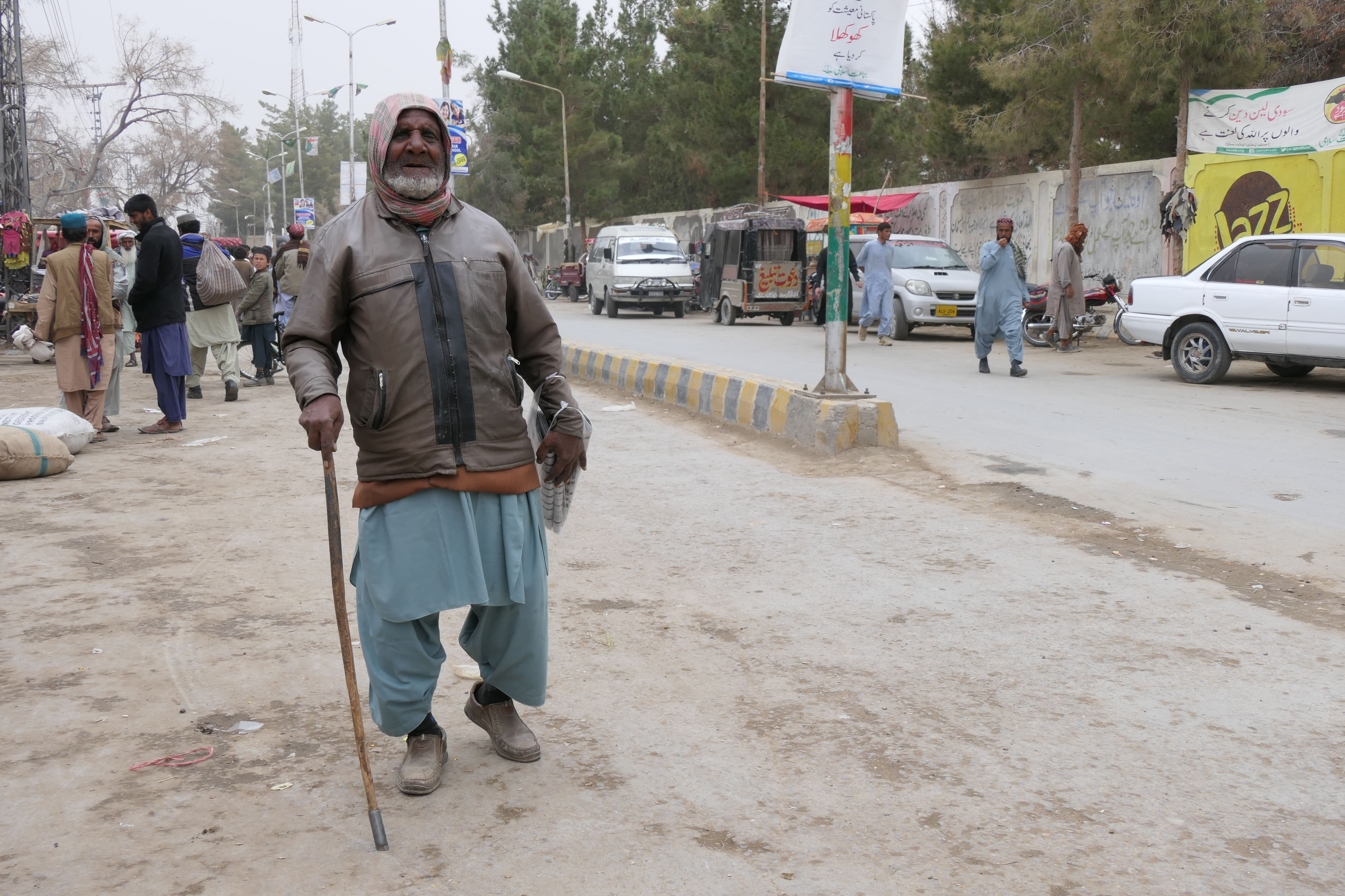 Muhammad Essa walking the streets with his walking stick and 22 newspapers to sell in Mastung city, Pakistan, on February 26, 2021. (AN Photo)