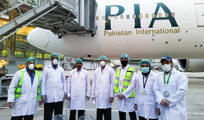PIA staff wearing masks posing in front of a grounded PIA plane on March 21, 2020. (Courtesy: PIA twitter)