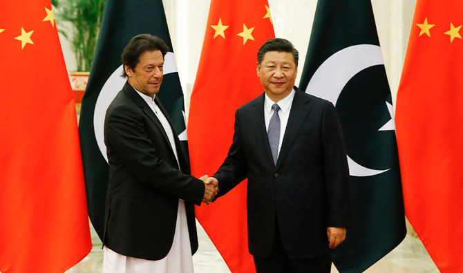 China's President Xi Jinping (R) shakes hands with Pakistan's Prime Minister Imran Khan (L) ahead of their meeting at the Great Hall of the People in Beijing on November 2, 2018. (AFP)