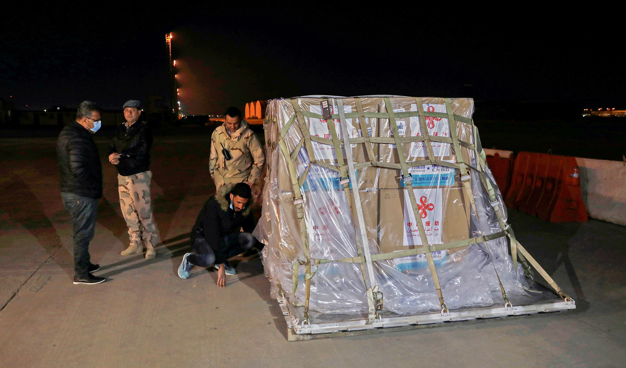 Personnel unload an aircraft carrying the first batch of doses of the Sinopharm vaccine against the coronavirus disease (COVID-19) after it arrived at Baghdad International Airport on March 2, 2021. (REUTERS)
