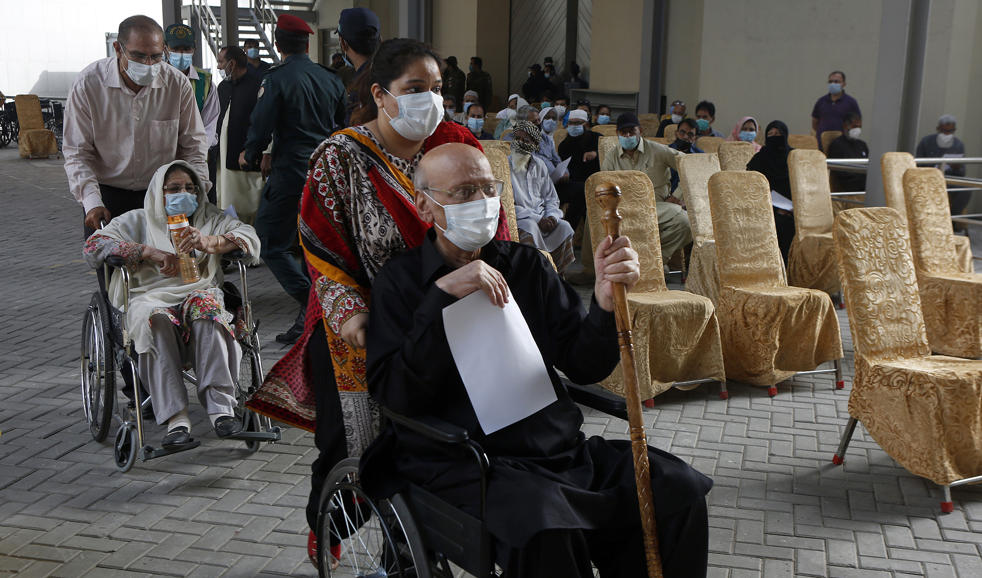 Senior citizens arrive to receive the Sinopharm coronavirus vaccine from a health worker at a vaccination center in Lahore, Pakistan, on March 18, 2021. (AP)