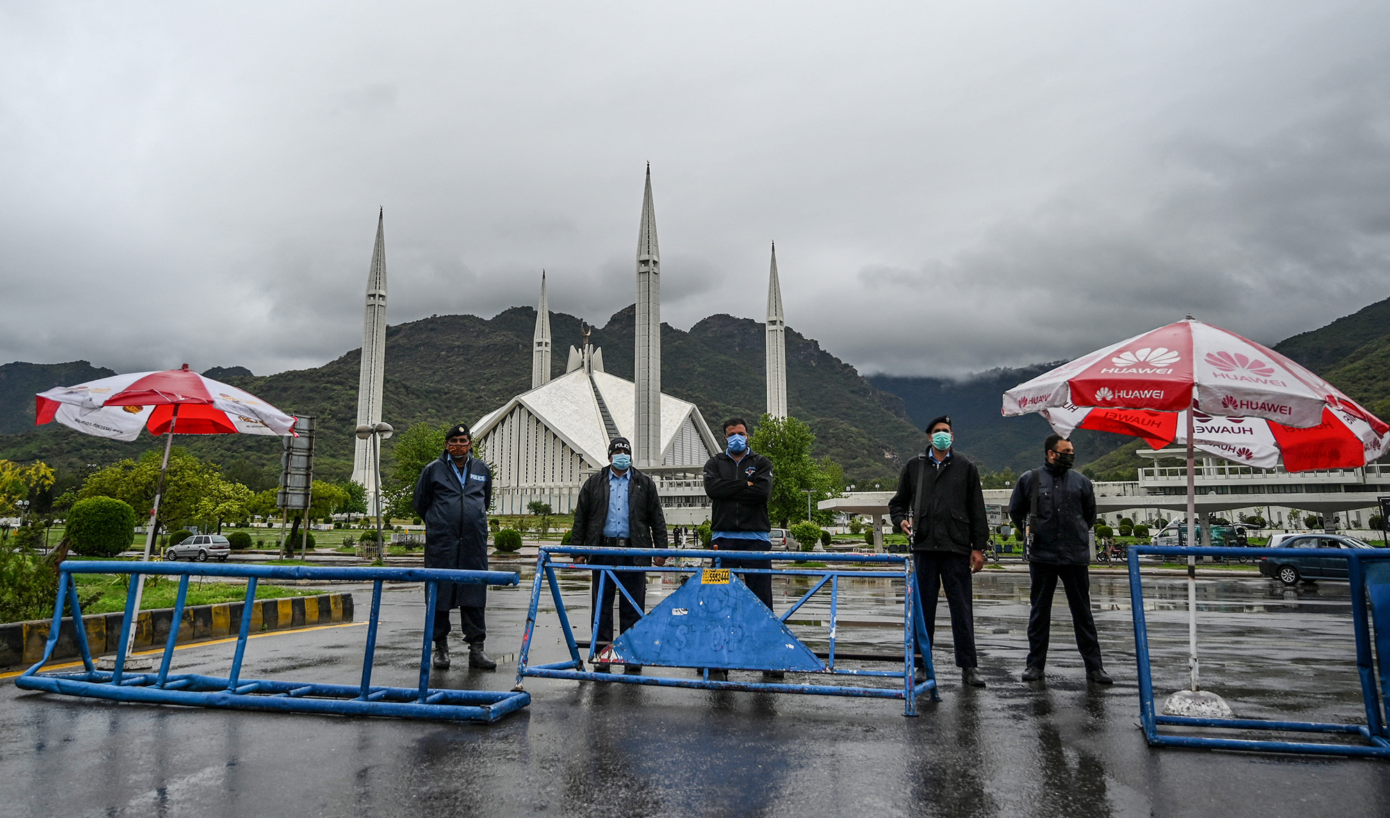 Policemen wearing facemasks stand guard at a checkpoint beside the Grand Faisal Mosque during a government-imposed nationwide lockdown as a preventive measure against the COVID-19 coronavirus, in Islamabad, Pakistan on March 27, 2020. (AFP/File)