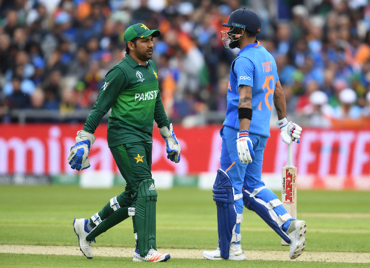 India's captain Virat Kohli (R) walks on the wicket with Pakistan's captain Sarfaraz Ahmed during the 2019 Cricket World Cup group stage match between India and Pakistan at Old Trafford in Manchester, northwest England, on June 16, 2019. (AFP)