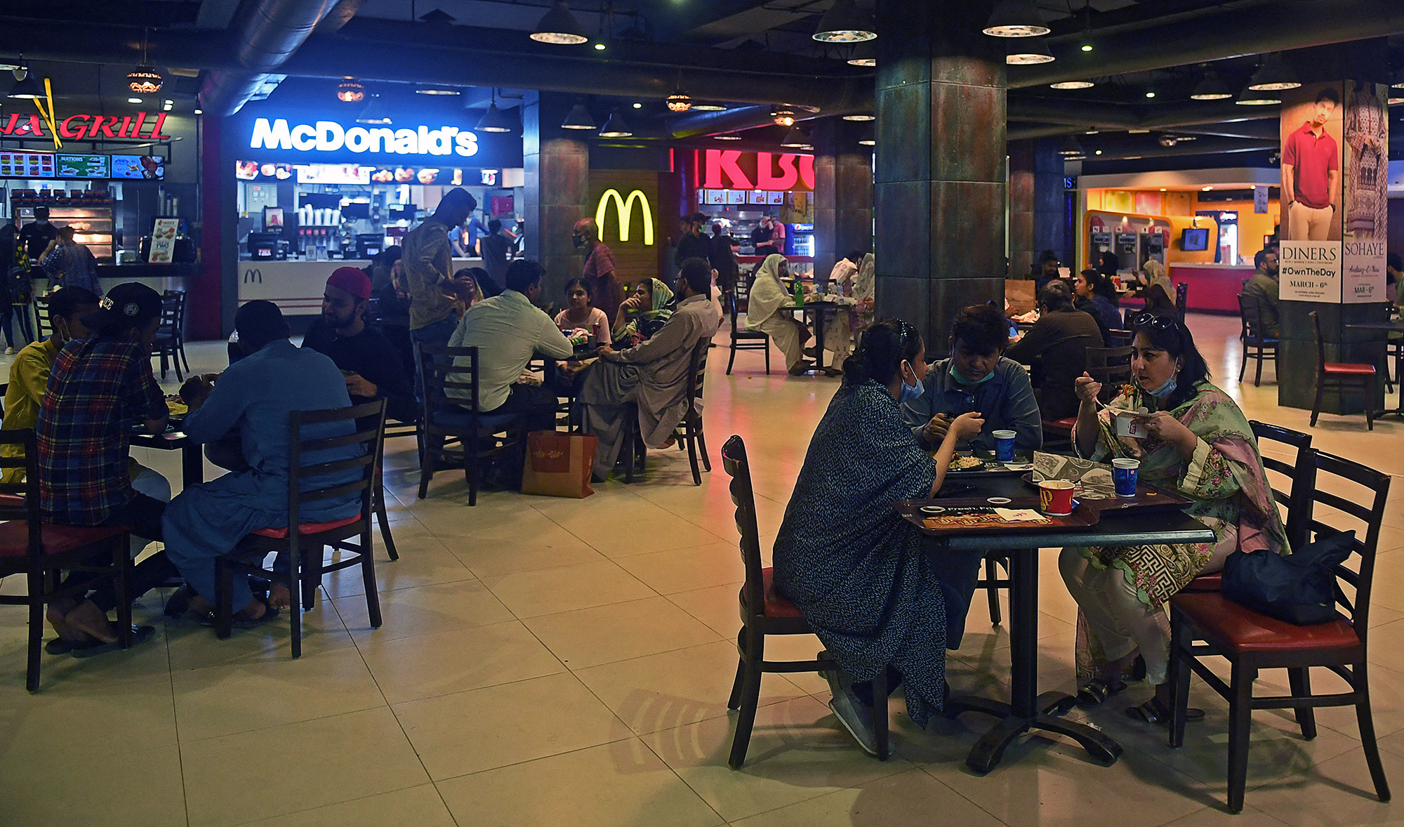 People eat at a food court in a mall in Karachi, Pakistan, on August 11, 2020. (AFP/File)