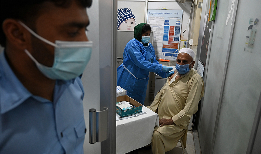 A senior citizen (R) receives a dose of the Chinese-made Sinopharm vaccine against the Covid-19 coronavirus, at a vaccination centre in Islamabad, Pakistan, on March 30, 2021. (AFP)