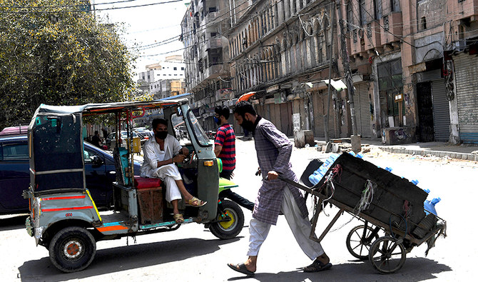 An auto-rickshaw driver wearing a facemask waits for customers on a street during a government-imposed nationwide lockdown as a preventive measure against the COVID-19 coronavirus, in Karachi on April 15, 2020. (AFP/File)
