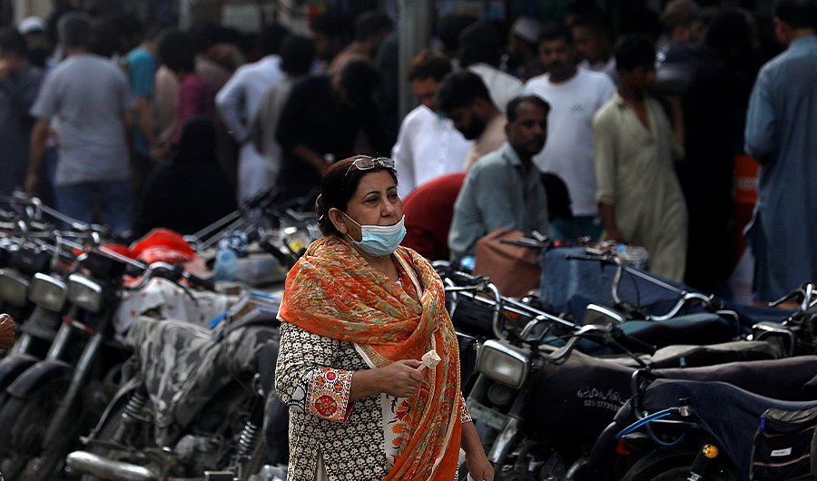 A woman wearing protective mask walks outside market, as the outbreak of coronavirus disease continues, in Karachi, Pakistan, on March 30, 2021. (REUTERS)