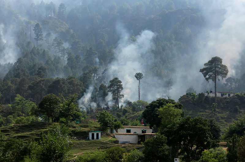 In this May 13, 2017, file photo, smoke rises in a civilian area at Bhawani village at Nowshera sector, along the highly militarized Line of Control that divides the region between India and Pakistan. (AP Photo)