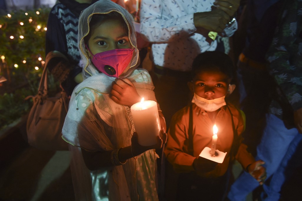 Christian devotees hold candles during an Easter vigil procession at Central Brooks Memorial Church, in Karachi on April 4, 2021. (AFP)