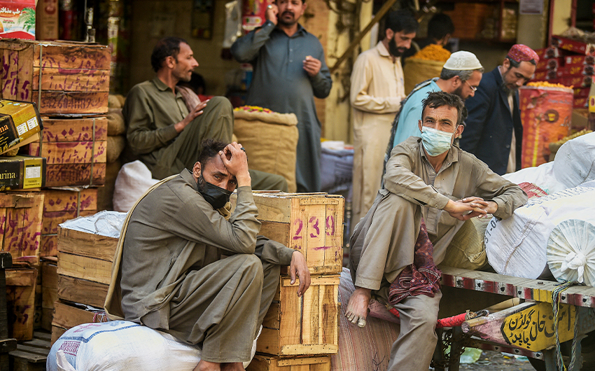 Laborers wait for customers at a market in Rawalpindi, Pakistan, on April 7, 2021. (AFP)