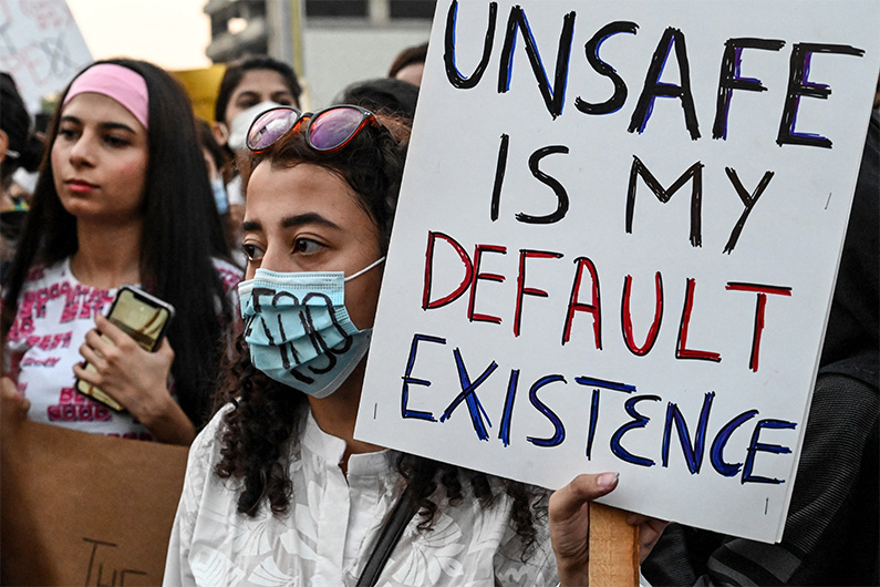 Human right activists hold placards as they march during a protest against an gang rape of a woman, in Lahore on September 12, 2020. (AFP)