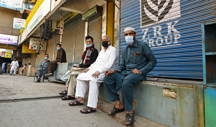 Shopkeepers sit at a closed market after a lockdown was imposed as a preventive measure against the Covid-19 in Rawalpindi, Pakistan, on April 3, 2021. (AFP)