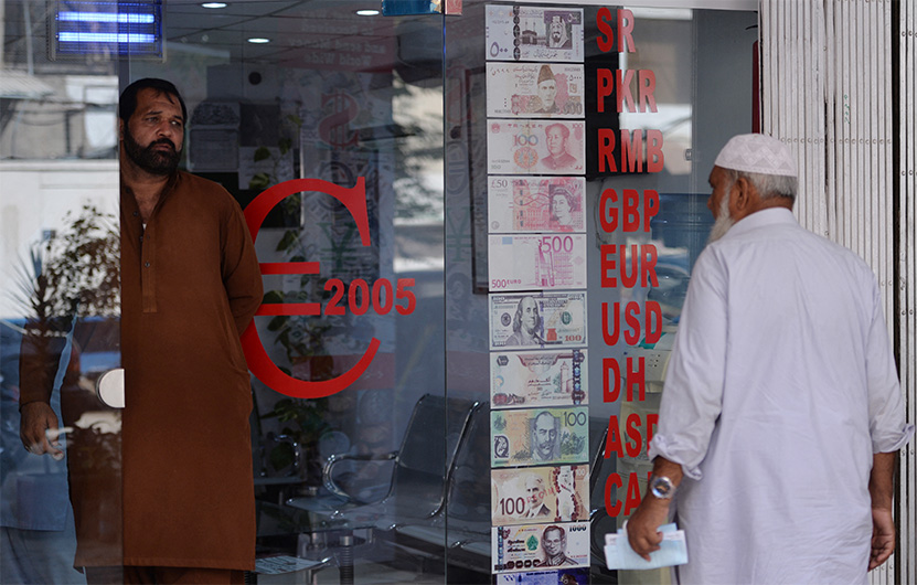 Pakistani customers enters at a currency exchange shop in Islamabad on October 9, 2018. (AFP)
