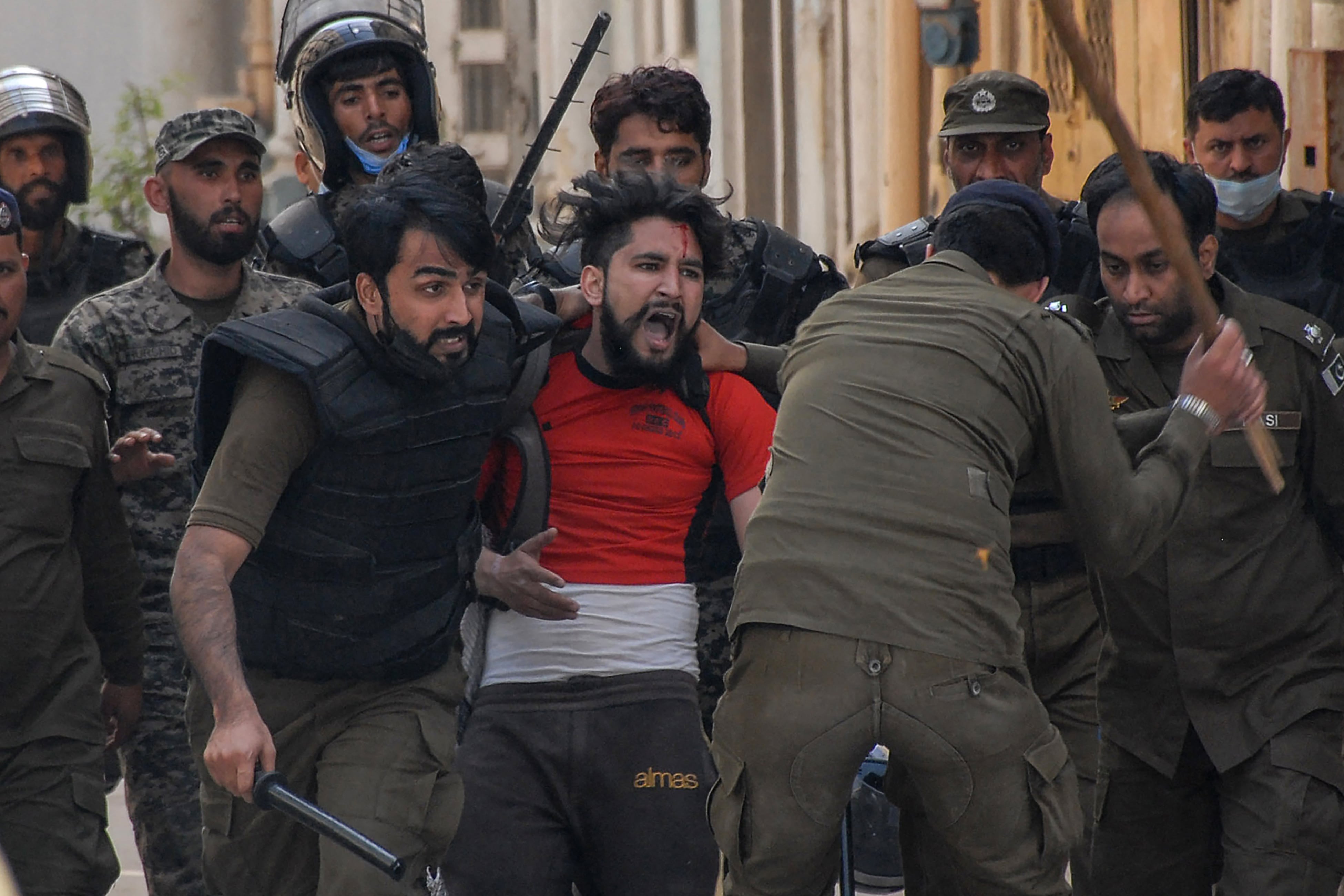 Policemen detain a supporter of Tehreek-e-Labbaik Pakistan (TLP) party during a protest against the arrest of their leader as he was demanding the expulsion of the French ambassador over depictions of Prophet Muhammad, in Rawalpindi on April 14, 2021. (AFP)