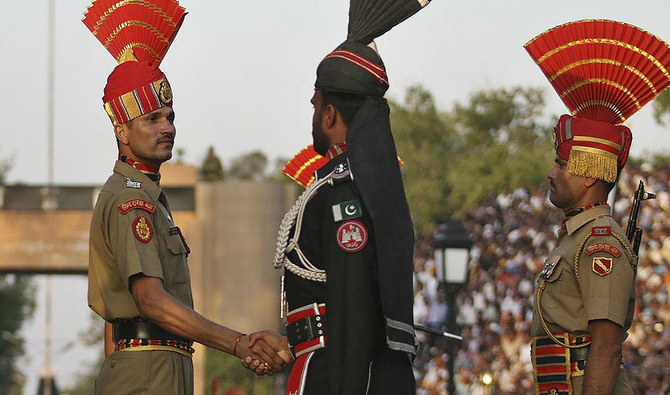 A Pakistani Ranger, center, and an Indian Border Security Force (BSF) officer, left, shake hands during the daily parade at the Pakistan-India joint check-post at Wagah border, Pakistan, on May 11, 2010. (REUTERS)