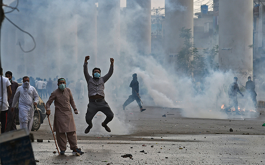 Police use tear gas to disperse supporters of Tehreek-e-Labbaik Pakistan (TLP) during a protest in Lahore on April 12, 2021, after the arrest of their leader, who has called for the expulsion of the French ambassador. (AFP)