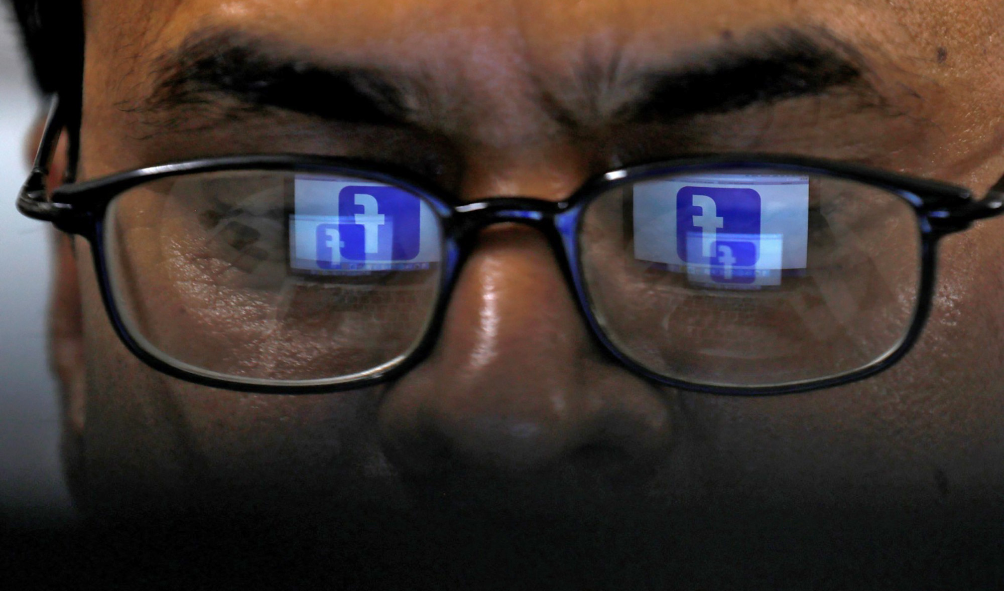 Reflection of Facebook logo appears in glasses of a Pakistani man in Karachi on April 1, 2019. (REUTERS/File)