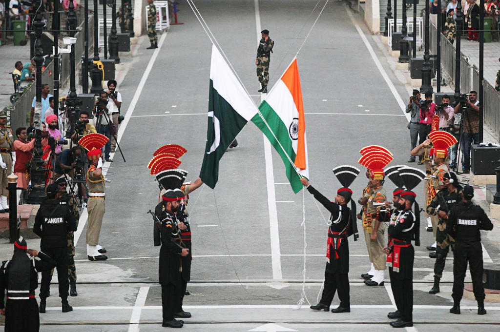 Pakistani Rangers (wearing black uniforms) and Indian Border Security Force (BSF) officers lower their national flags during parade on the Pakistan's 72nd Independence Day, at the Pakistan-India joint check-post at Wagah border, near Lahore, Pakistan August 14, 2019. (Reuters/File)
