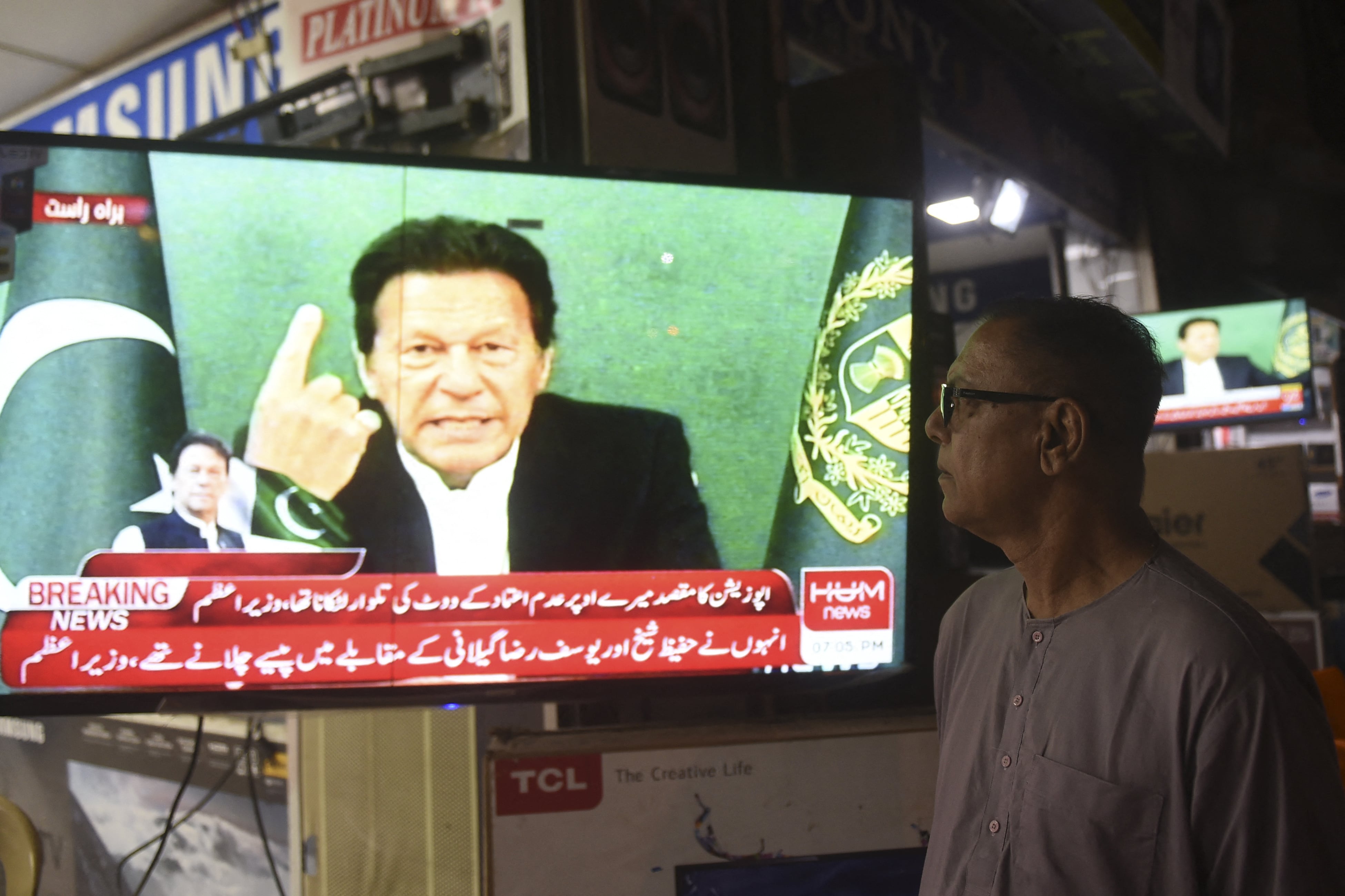 A bystander listens to Pakistan's Prime Minister Imran Khan addressing the nation on television, in Karachi on March 4, 2021 (AFP /File photo)