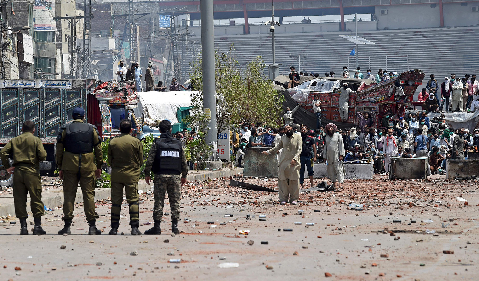Policemen stand guard as supporters of Tehreek-e-Labbaik Pakistan (TLP) party take part in a protest while blocking a street after their leader was detained following his calls for the expulsion of the French ambassador, in Lahore on April 18, 2021. (AFP)
