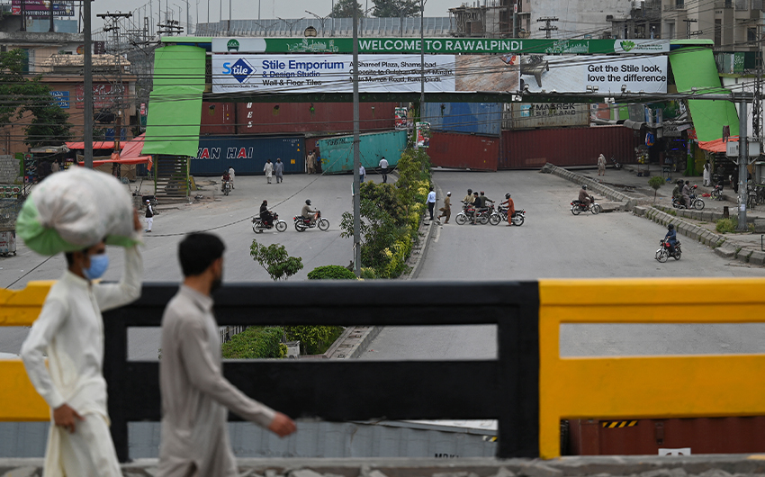 People return on the main entry point between Rawalpindi and Islamabad which was blocked with shipping containers in Rawalpindi, Pakistan, on April 20, 2021. (AFP)