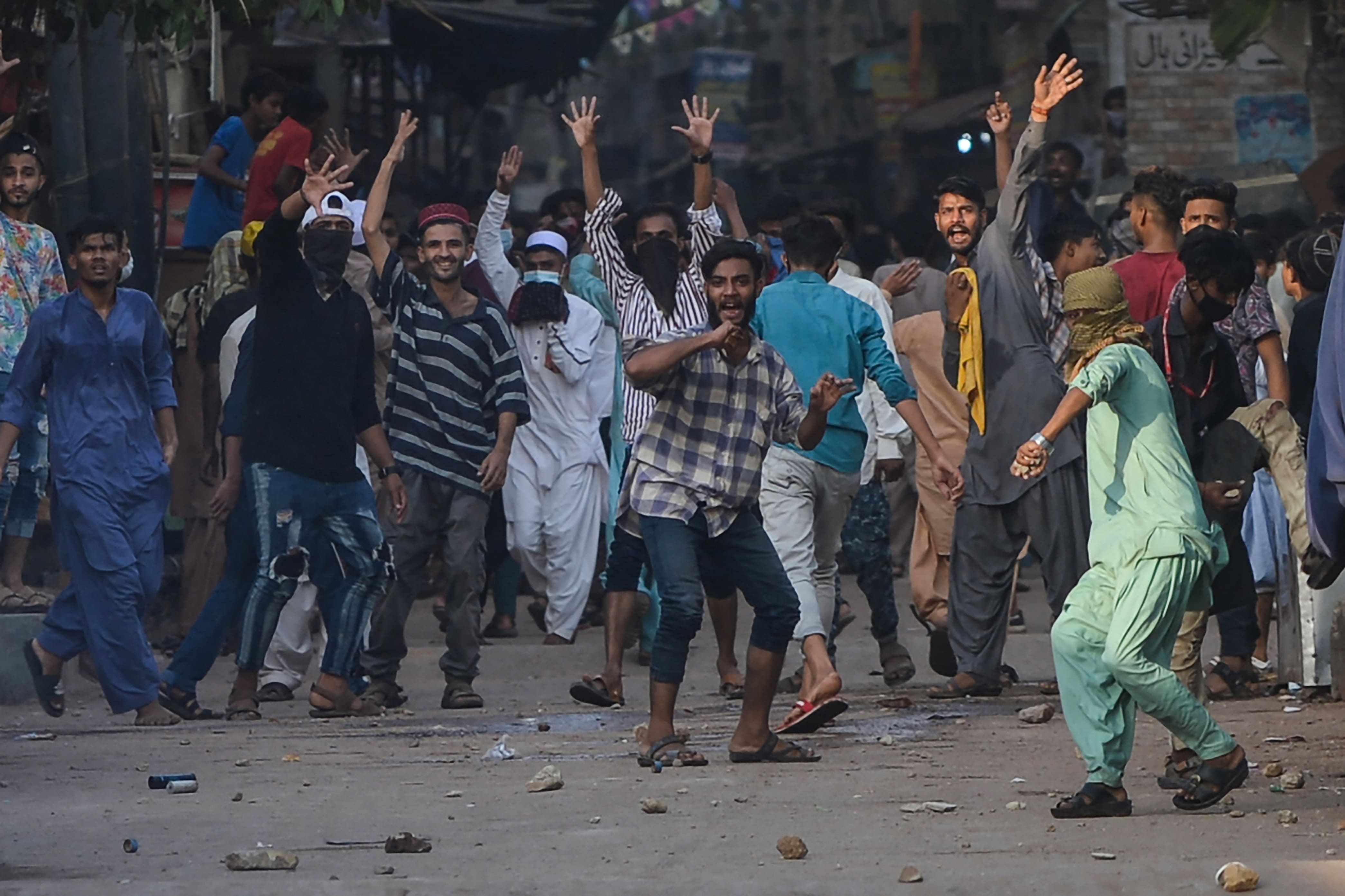 Supporters of Tehreek-e-Labbaik Pakistan (TLP) party throw stones toward police during a protest after their leader was detained following his calls for the expulsion of the French ambassador, in Karachi on April 19, 2021. (AFP)