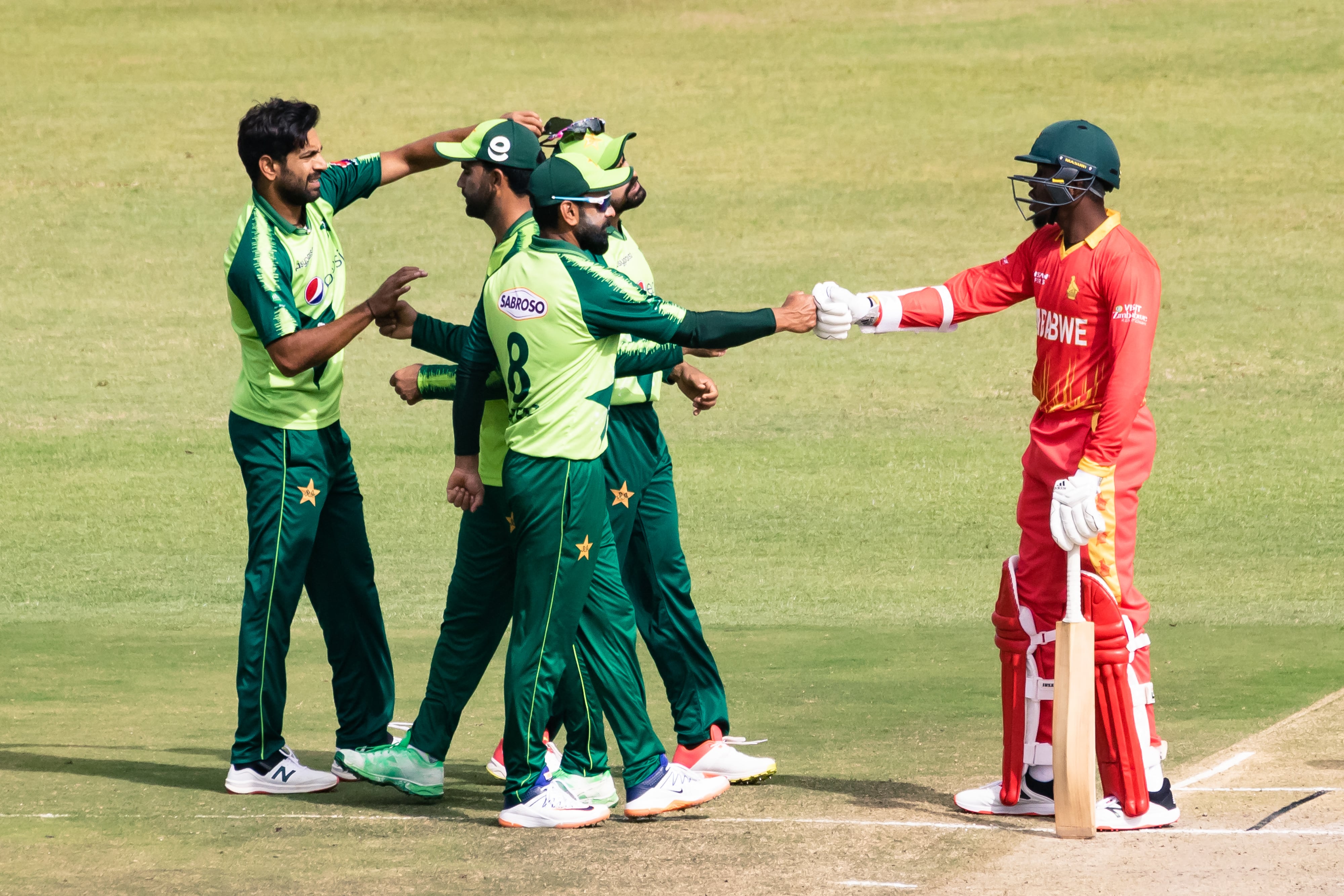 Zimbabwe's Wellington Masakadza (R) bumps fists with Pakistan after Pakistan's victory after the first Twenty20 international cricket match between Zimbabwe and Pakistan at the Harare Sports Club in Harare on April 21, 2021. (AFP)