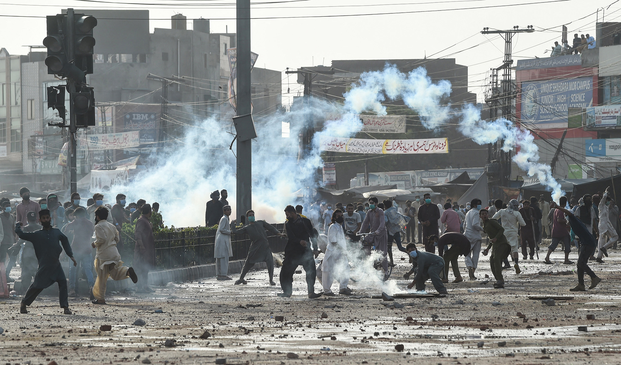 Supporters of Tehreek-e-Labbaik Pakistan (TLP) party throw stones towards police during a protest against the arrest of their leader Saad Rizvi, in Lahore, Pakistan, on April 13, 2021. (AFP)