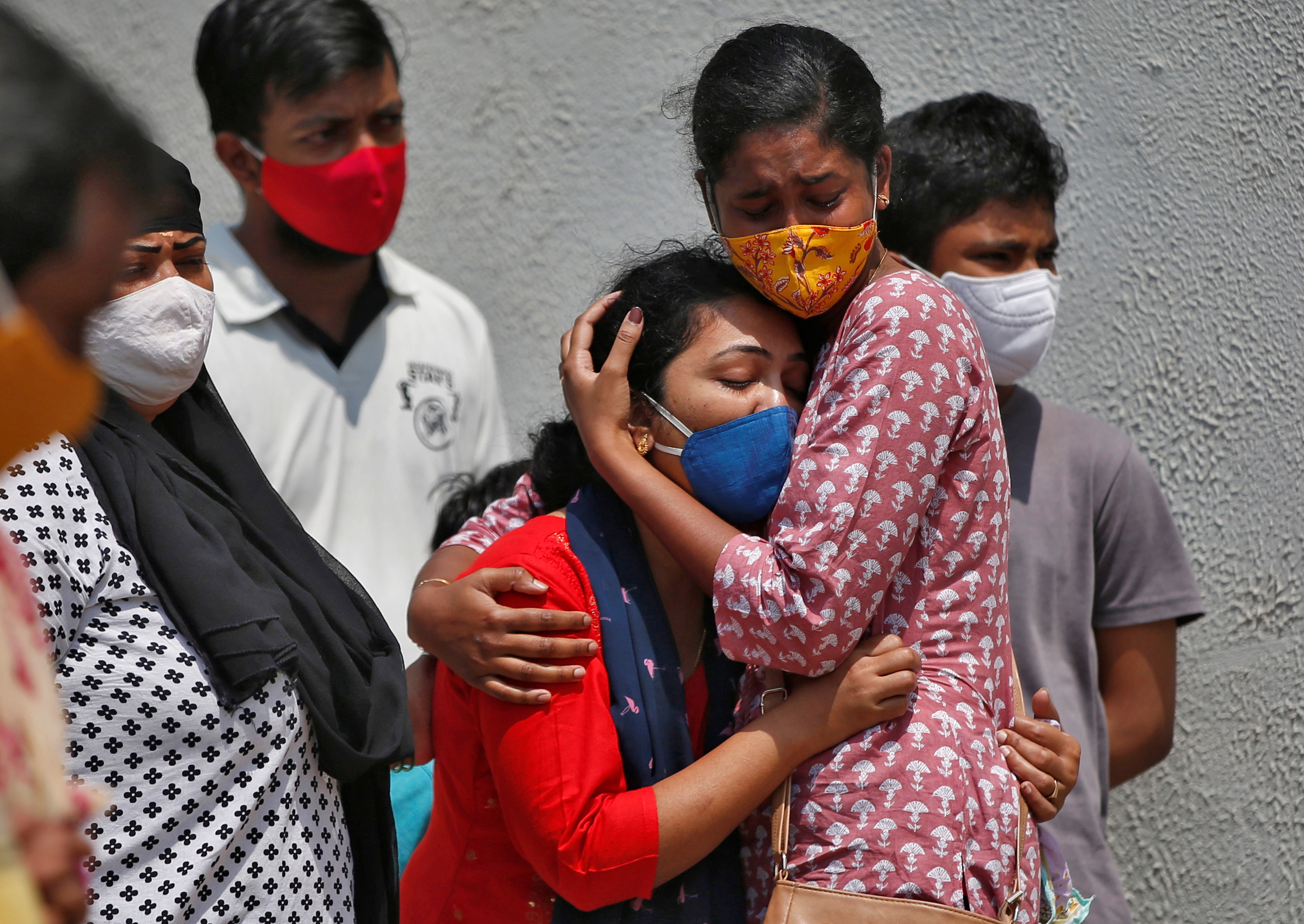A woman is consoled after her husband died due to the coronavirus disease (COVID-19) outside a mortuary of a COVID-19 hospital in Ahmedabad, India, April 15, 2021. (REUTERS)