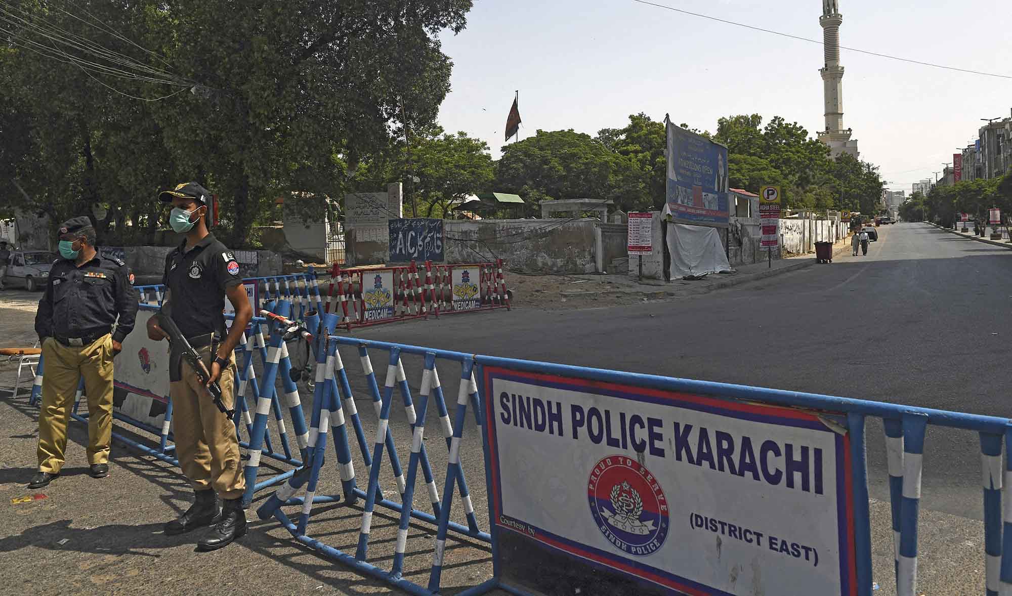 Security personnel wearing facemasks stand guard in a sealed residential area in Karachi, Pakistan, on June 19, 2020. (AFP/File)