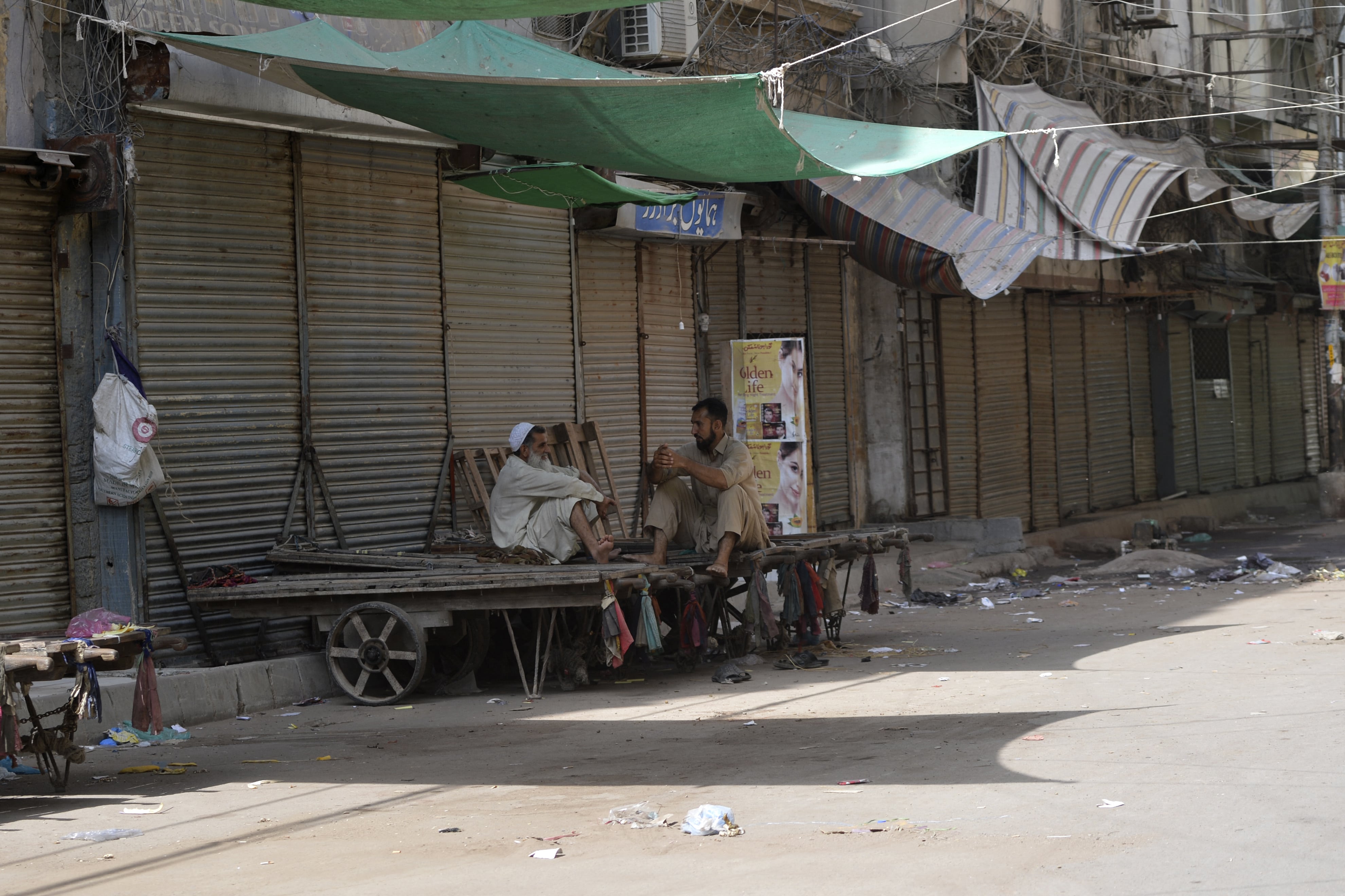 Labourers sit on handcarts in a shuttered market after a lockdown was imposed to control the spread of the Covid-19 coronavirus in Karachi on April 11, 2021. (AFP)