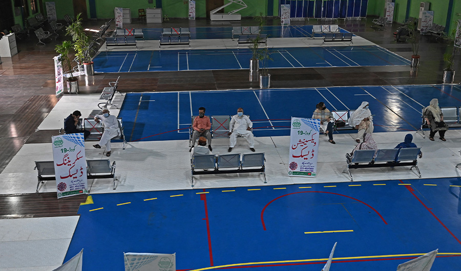 People wait for their turn to receive dose of the Chinese-made Sinopharm vaccine against the Covid-19 coronavirus at a vaccination centre settled inside Sports Complex in Rawalpndi on April 12, 2021. (AFP)