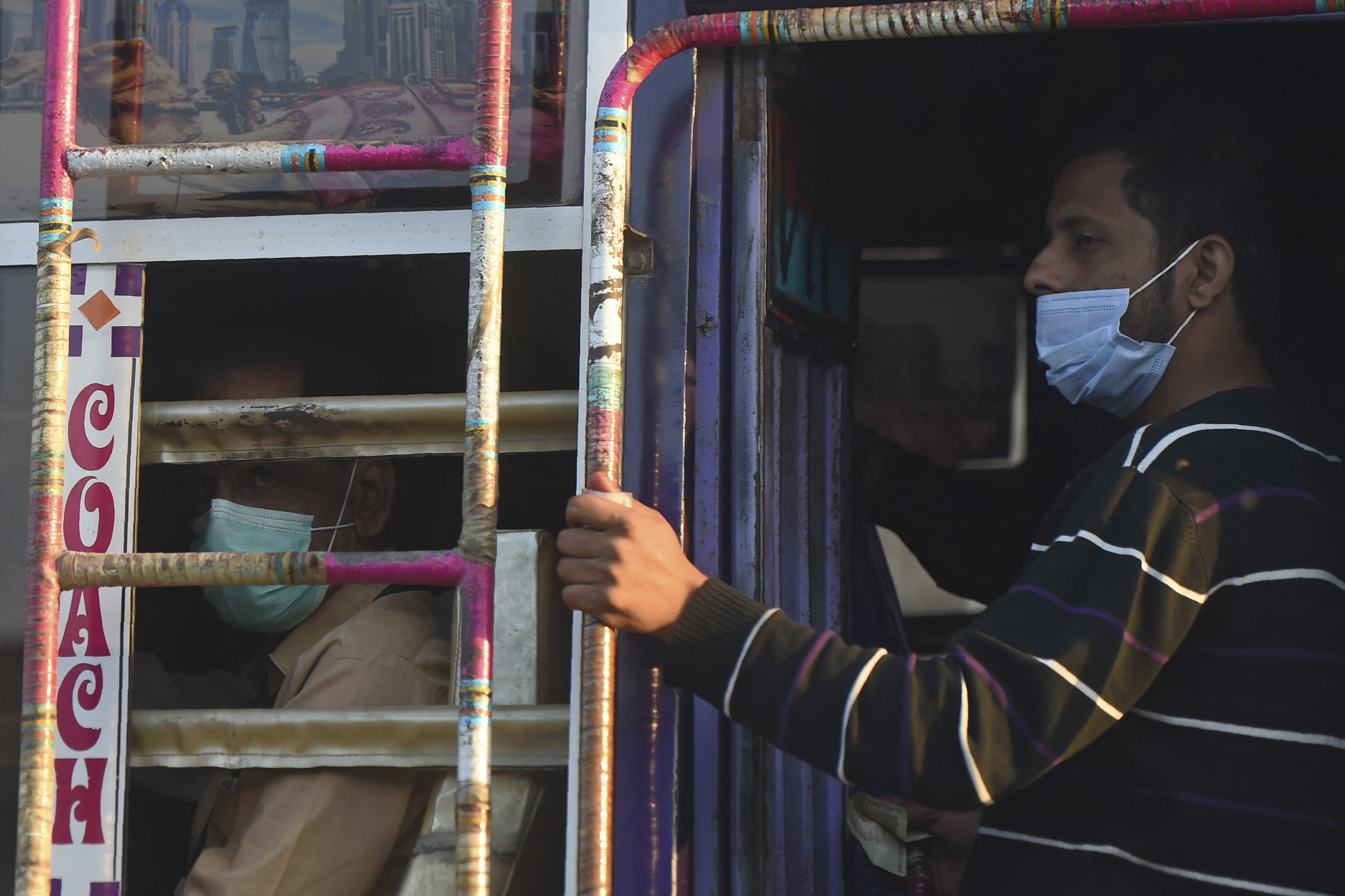 People wearing facemasks as a preventive measure against the Covid-19 coronavirus travel on a passenger bus in Karachi on November 26, 2020. (AFP)