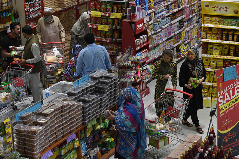 Muslim people buy grocery items at a store ahead of the Holy month of Ramadan in Peshawar on April 5, 2021. (AFP)